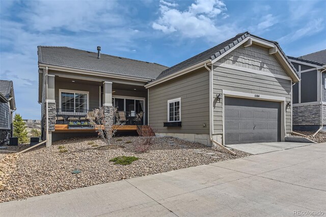 craftsman inspired home with a garage, a porch, and concrete driveway