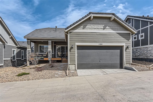 view of front of property featuring covered porch, a garage, and driveway