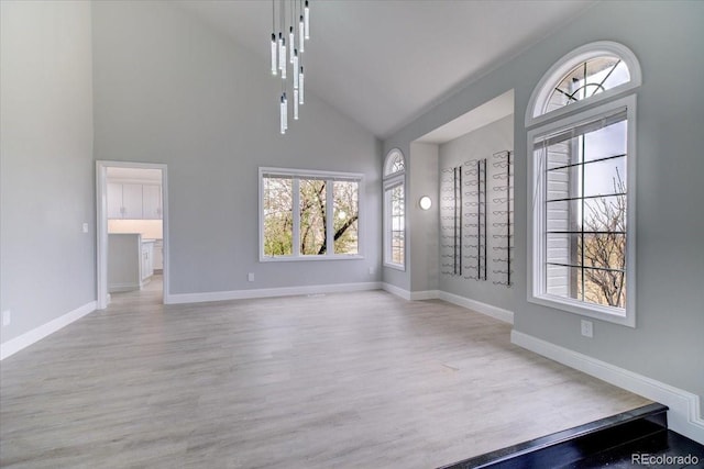 interior space with light wood-type flooring and high vaulted ceiling