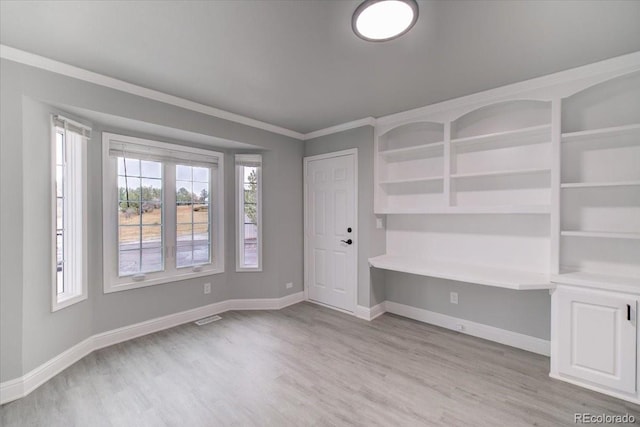 spare room featuring light hardwood / wood-style floors and ornamental molding