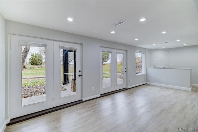 doorway with plenty of natural light and light hardwood / wood-style flooring