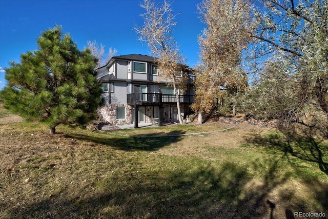 back of property with a yard and a wooden deck