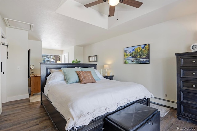 bedroom with ceiling fan, dark hardwood / wood-style floors, and a baseboard heating unit