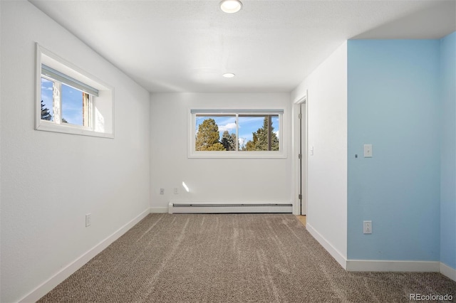 carpeted spare room featuring baseboard heating