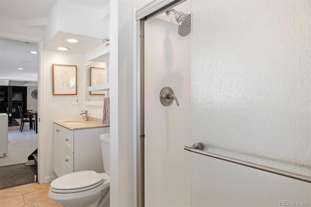 bathroom featuring tile patterned floors, vanity, toilet, and a shower