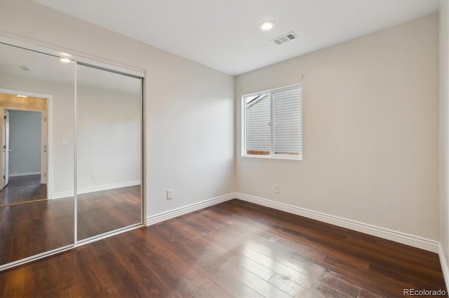 unfurnished bedroom with visible vents, baseboards, dark wood finished floors, a closet, and recessed lighting