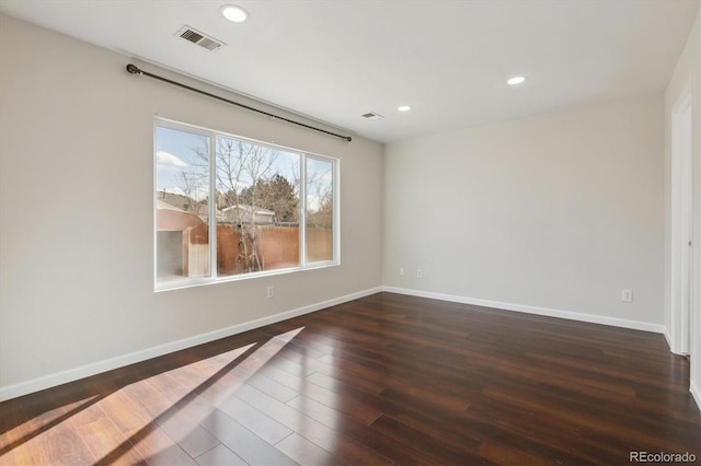 unfurnished room featuring dark wood-type flooring, recessed lighting, visible vents, and baseboards