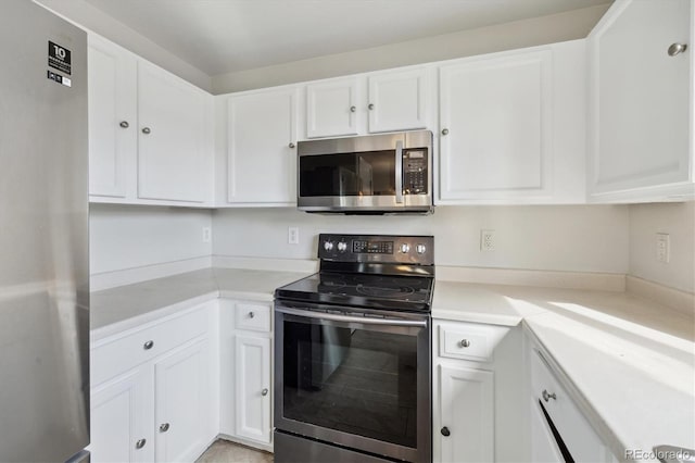 kitchen with white cabinets, appliances with stainless steel finishes, and light countertops