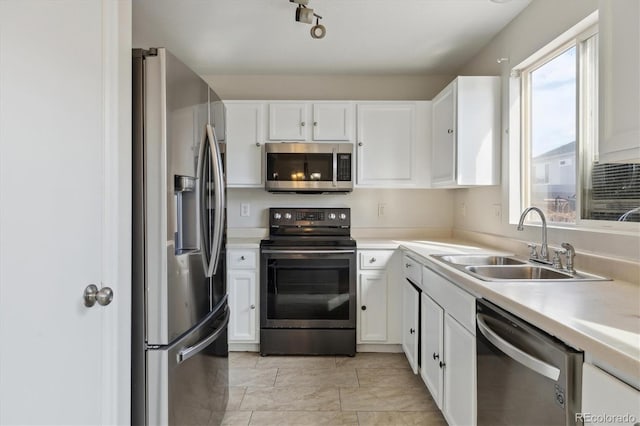 kitchen featuring light countertops, appliances with stainless steel finishes, a sink, and white cabinets