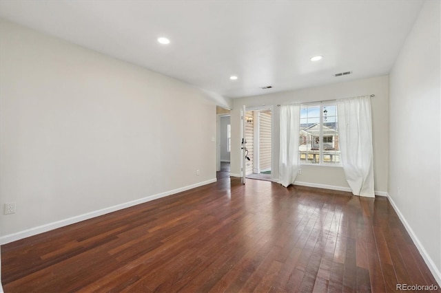 empty room with dark wood-type flooring, recessed lighting, visible vents, and baseboards