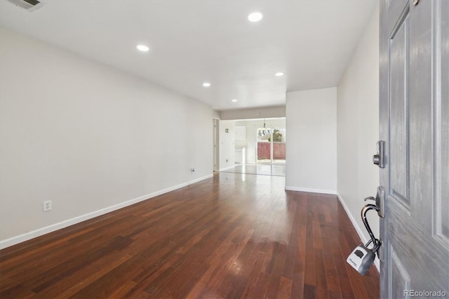 interior space with recessed lighting, a notable chandelier, dark wood finished floors, and baseboards