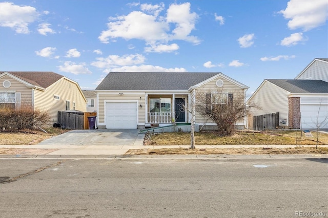 view of front of property featuring a garage, a porch, driveway, and fence