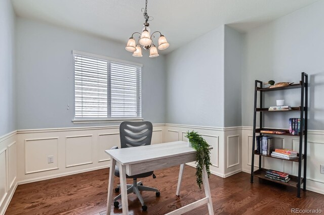 5181 Delphinium Cir, Brighton, CO 80601 - home office with a chandelier, dark wood-type flooring, a wainscoted wall, and a decorative wall