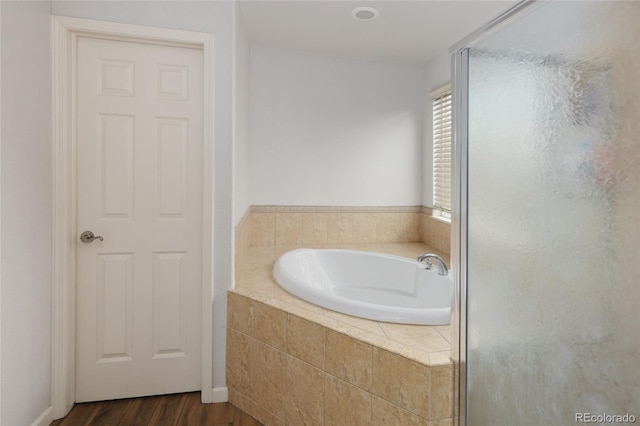 bathroom with hardwood / wood-style flooring and shower with separate bathtub