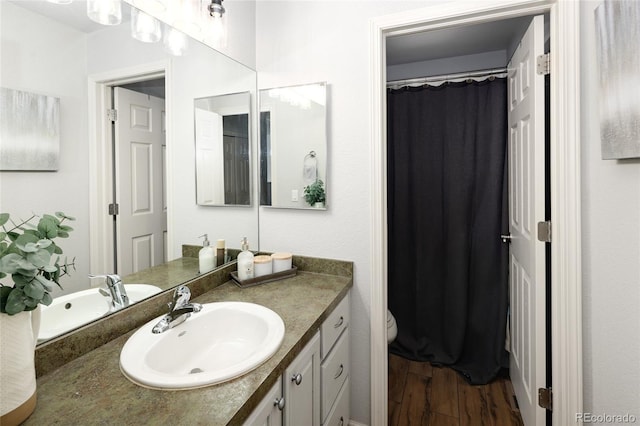 bathroom with vanity, hardwood / wood-style floors, and toilet