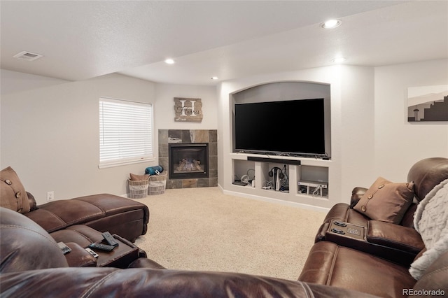 living room featuring carpet floors, a tile fireplace, and built in features