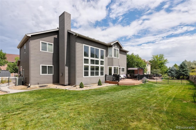 rear view of property featuring a wooden deck, a yard, and central AC