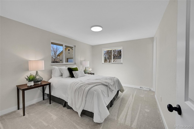 bedroom with multiple windows and light carpet