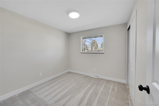 unfurnished bedroom with light carpet and a closet