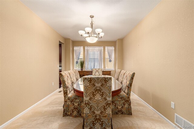 dining room featuring a notable chandelier and light colored carpet