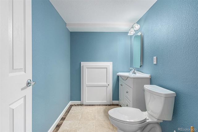 bathroom featuring tile patterned flooring, a textured ceiling, vanity, and toilet