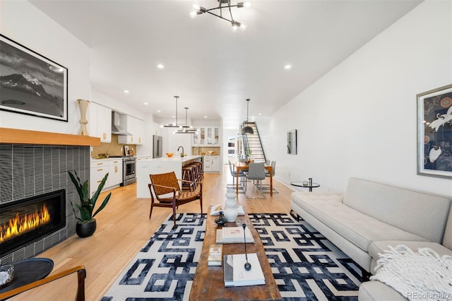 4227 Mariposa St, Denver, CO 80211 - living room with light wood finished floors, a chandelier, a fireplace, and recessed lighting