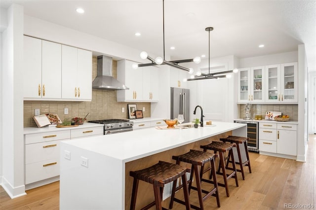 4227 Mariposa St, Denver, CO 80211 - kitchen with wall chimney exhaust hood, wine cooler, appliances with stainless steel finishes, a sink, and backsplash