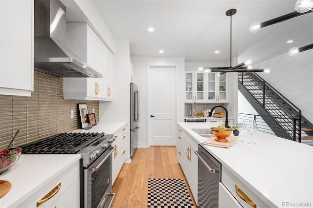 4227 Mariposa St, Denver, CO 80211 - kitchen featuring wall chimney exhaust hood, appliances with stainless steel finishes, a sink, white cabinetry, and light countertops