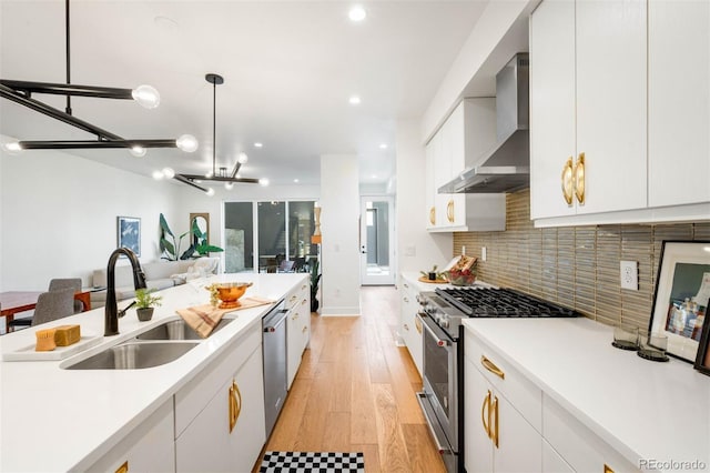 4227 Mariposa St, Denver, CO 80211 - kitchen featuring stainless steel appliances, a sink, wall chimney exhaust hood, light countertops, and white cabinetry