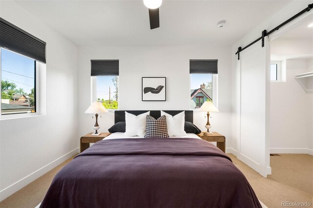 4227 Mariposa St, Denver, CO 80211 - bedroom with a barn door, light colored carpet, baseboards, and a ceiling fan