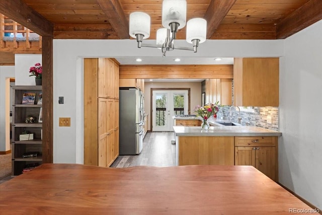 11724 Little Turtle Ln, Conifer, CO 80433 - kitchen with freestanding refrigerator, a sink, a chandelier, a peninsula, and wooden ceiling