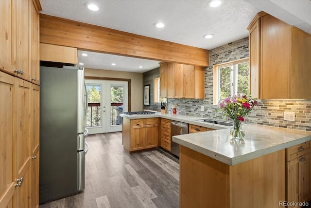 11724 Little Turtle Ln, Conifer, CO 80433 - kitchen featuring stainless steel appliances, a peninsula, a sink, light countertops, and tasteful backsplash