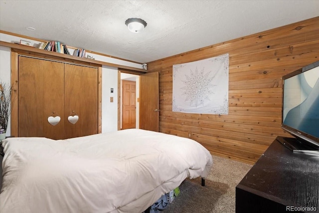 11724 Little Turtle Ln, Conifer, CO 80433 - carpeted bedroom with wood walls, a closet, and a textured ceiling