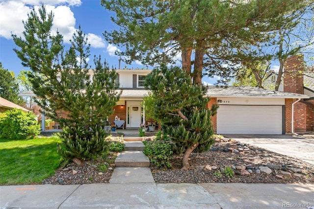 7970 S Cook Way, Centennial, CO 80122 - view of property hidden behind natural elements featuring a garage, brick siding, and driveway