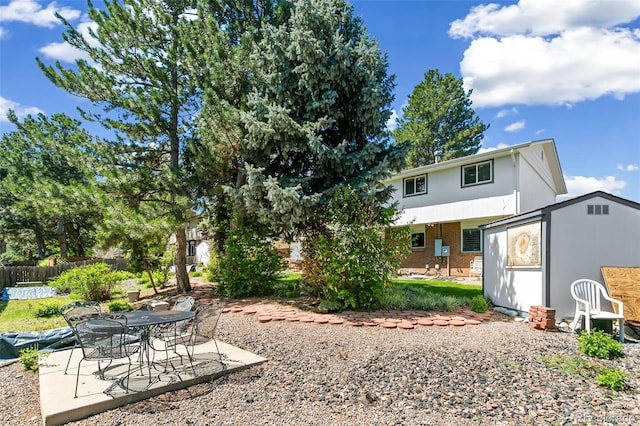 7970 S Cook Way, Centennial, CO 80122 - back of property featuring a patio area, fence, brick siding, an outdoor structure, and a storage shed