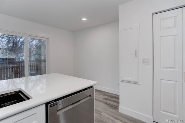 11973 E Kepner Dr, Aurora, CO 80012 - kitchen featuring stainless steel dishwasher, baseboards, light wood-style floors, white cabinetry, and light countertops