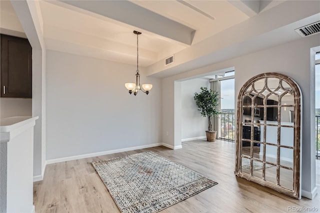 dining room featuring light hardwood / wood-style floors, an inviting chandelier, and beamed ceiling