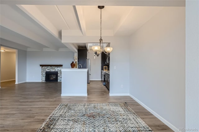 dining room with dark hardwood / wood-style floors, beam ceiling, a chandelier, and a fireplace