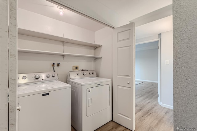 laundry room with independent washer and dryer and light hardwood / wood-style floors