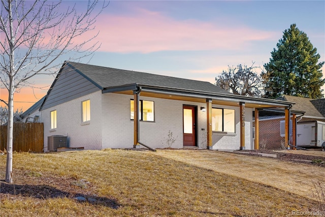 view of front of home with a lawn and central air condition unit