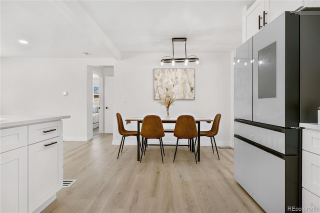 dining room with an inviting chandelier and light hardwood / wood-style flooring