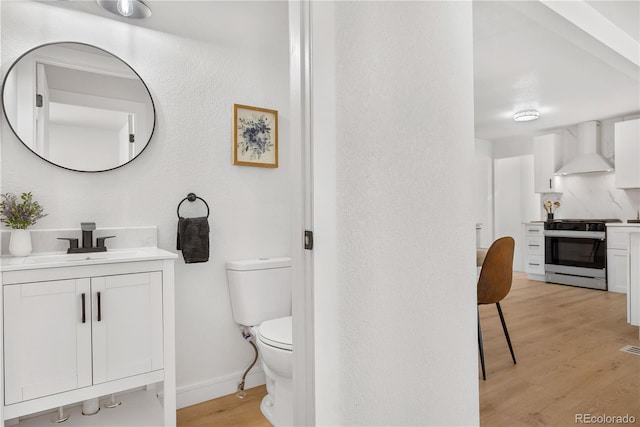 bathroom featuring hardwood / wood-style flooring, vanity, and toilet