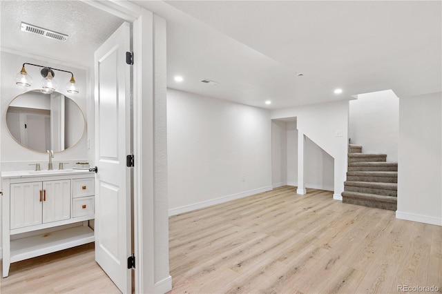 basement with sink and light wood-type flooring