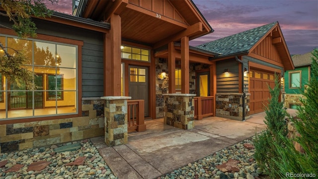 exterior entry at dusk featuring a garage