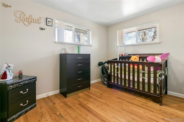 150 S Hooker St, Denver, CO 80219 - bedroom featuring wood finished floors, multiple windows, and a nursery area