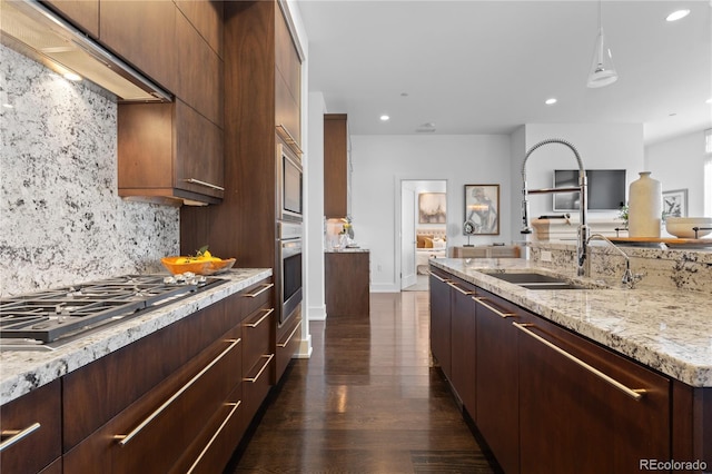 kitchen with dark wood-type flooring, sink, tasteful backsplash, stainless steel appliances, and light stone countertops