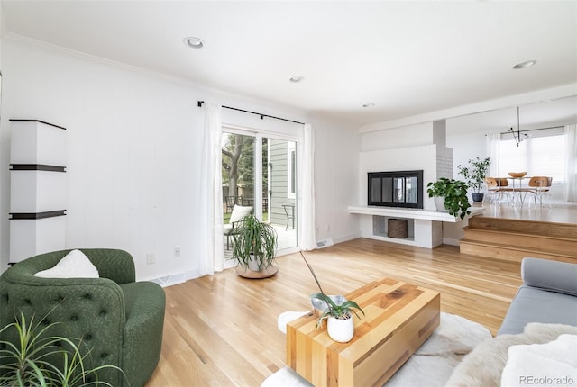 living area with baseboards, a healthy amount of sunlight, and wood finished floors