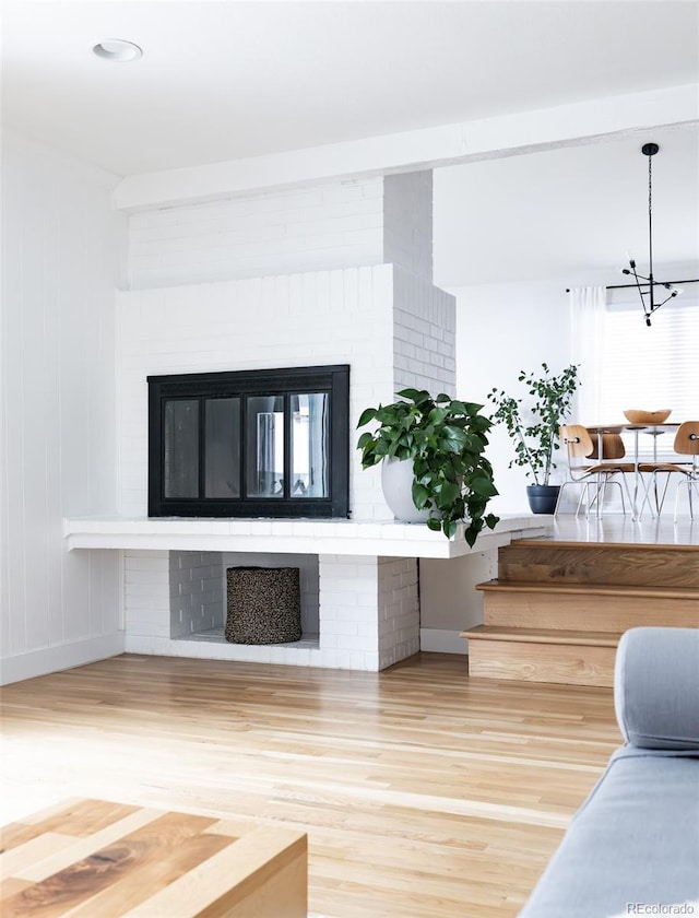 living room featuring baseboards, wood finished floors, and a fireplace