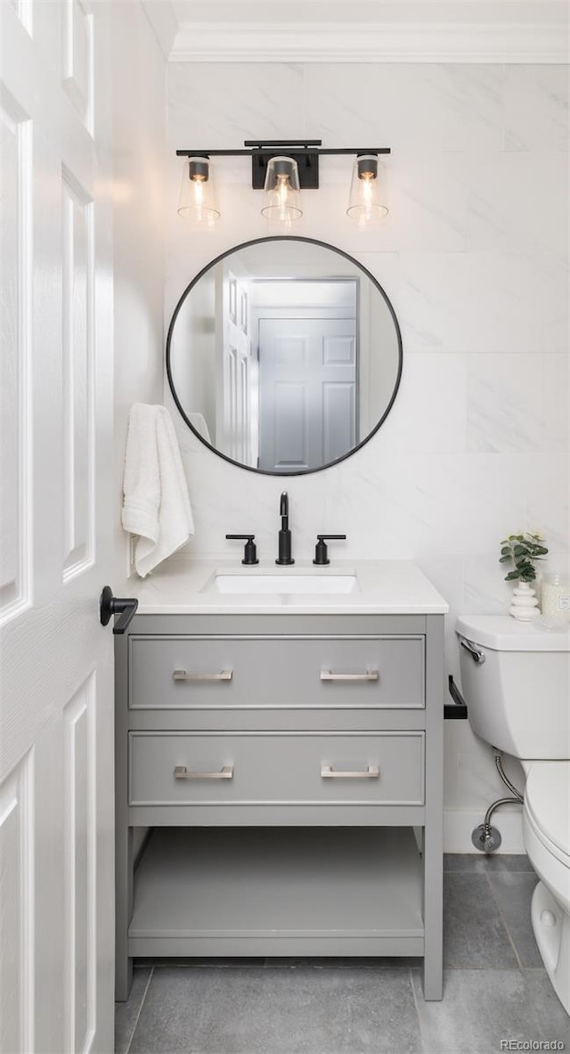 bathroom featuring vanity, crown molding, tile patterned floors, and toilet