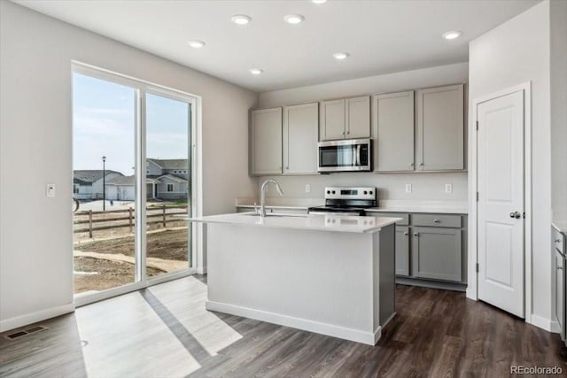 14378 Heritage Dr, Mead, CO 80504 - kitchen with a sink, light countertops, stainless steel appliances, gray cabinetry, and dark wood-style floors